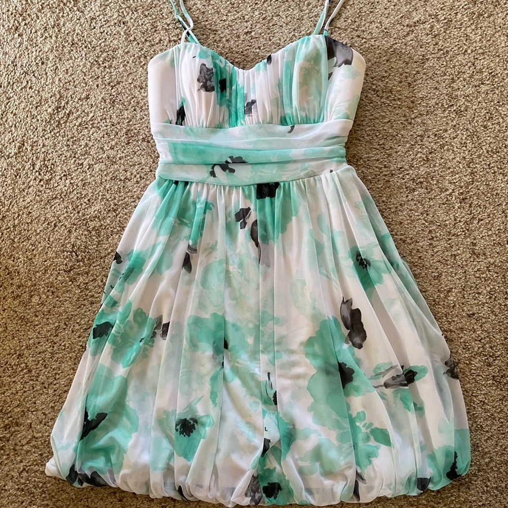 medium white dress has straps, green flowers, bow on the back, brand: speechless